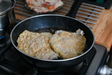 Frying pork chops in hot fat.
