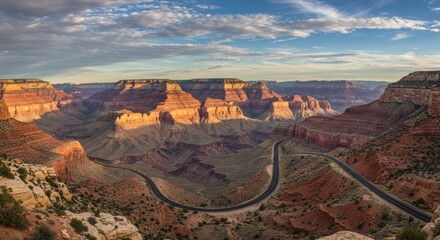 Scenic aerial perspective of a vast canyon landscape with winding road under a cloudy sky