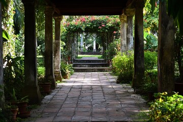 Fototapeta premium Sun-drenched garden path, columns, arches