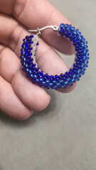 Handmade round earrings made of seed beads and glass beads on a light background