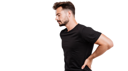 Man experiencing back pain, standing with one hand on his lower back, white isolated background.