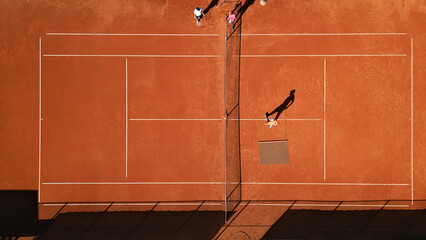 Tennis groundskeeper cleans a surface on a clay court. Overhead aerial shot highlights the court layout and athletes' dedication to skill development. © wkproduction