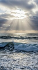 Obraz premium Sunbeams pierce through clouds over ocean waves, creating ethereal light