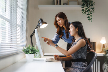 Businesswomen collaborating on computer discussing project