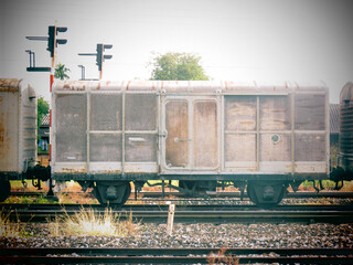 Old industrial railway station in the thailand with a train on the tracks under the sky