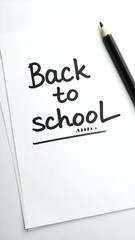 Handwritten "Back to School" on white paper, black pencil beside