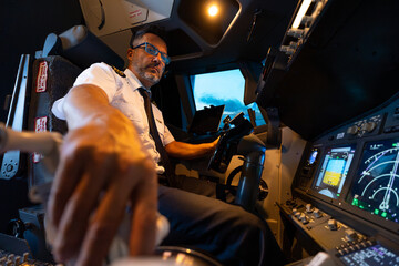 Commercial airline pilot operating flight simulator controls © Martí Rosselló