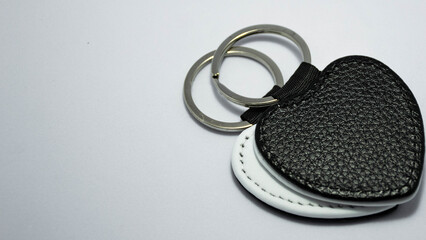 Black and white leather keychains on a white background, prepared as engraving blanks. Concept of...