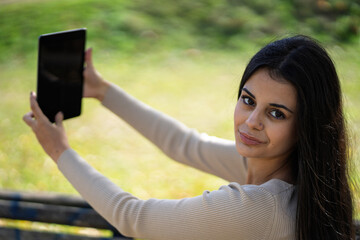 Woman taking selfie using tablet in park © EDUARDOIVAN