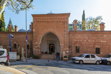 Historic Muradiye Madrasa in Bursa with Ottoman brick architecture, arched entrance and domed roof.