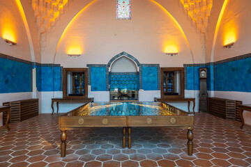 Interior of Muradiye Madrasa in Bursa with blue Iznik tiles, arched design and illuminated exhibition hall. 