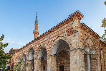 Orhan Mosque in Bursa with Ottoman stone and brick architecture, arches, domes and tall minaret.