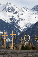 Winter Graveyard in Tyrol with Traditional Forged Crosses and Snow-Capped Alps 