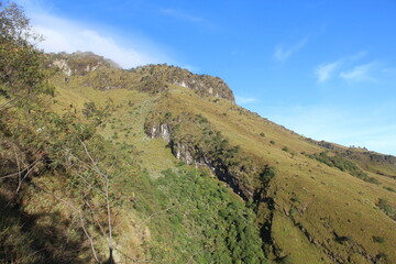 Scenic outdoor photograph capturing a steep mountain slope under a clear blue sky