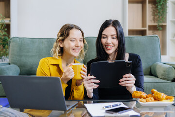 Happy woman couple working on a laptop at home, enjoying a relaxed and modern lifestyle. remote work.