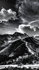 Dramatic black and white mountain vista with dramatic clouds and stars