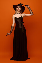 Beautiful young woman embodies Halloween spirit in elegant witch costume with striking details