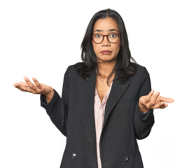 Young Latina professional in studio doubting and shrugging shoulders in questioning gesture.