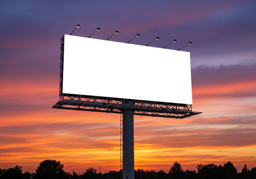 Striking blank billboard illuminated against a vibrant, fiery sunset sky, ready for your impactful advertisement and brand message.