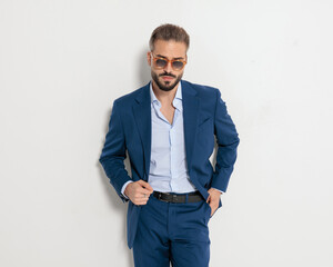 Fototapeta premium cool fashion businessman with sunglasses holding hands in pockets