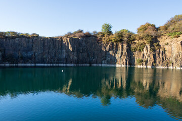 Prestonhill Quarry, Inverkeithing, Fife, Scotland—a dramatic, rugged landscape featuring towering...