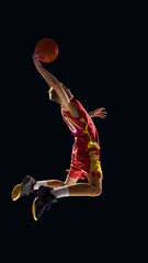 Basketball player rising for slam dunk with powerful leap under spotlight. Concept of motivation, advertising, fitness branding, social campaigns, and emotional energy in sports. © master1305
