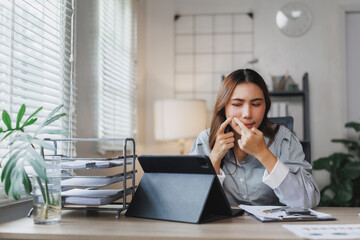 Businesswoman squeezing pimple while working from home office