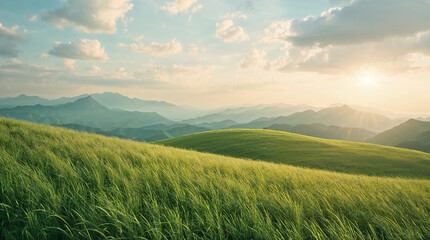Fototapeta premium Golden hour sunset over lush green rolling hills and layered mountains with warm sky
