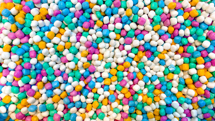 Close up of colorful decorative stones, small polished gravel in mixed pastel tones, used for decoration and background texture.