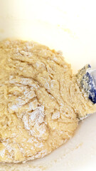 Raw cupcake batter with flour and spatula in bowl