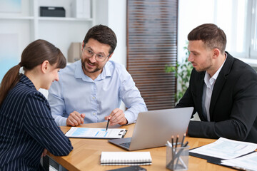 Couple having meeting with business consultant at table in office