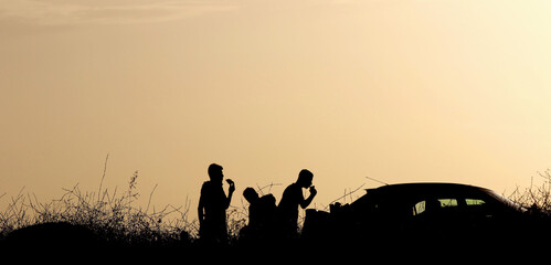 Children eating watermelon at sunset on a mountainside