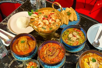 Authentic Thai Sour Curry with Sea Bass (Gaeng Som) Served with Steamed Jasmine Rice in a Restaurant Setting
