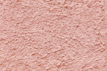 A pink wall with a textured surface