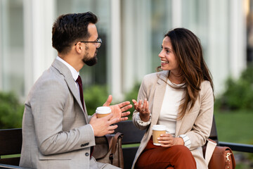 Business people talking and having coffee outdoors during break