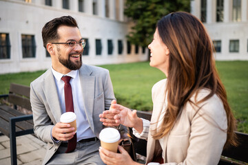 Business people talking and smiling during coffee break outdoors