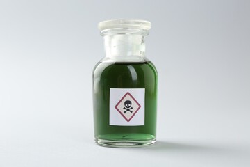 Bottle of poison with warning sign on light background
