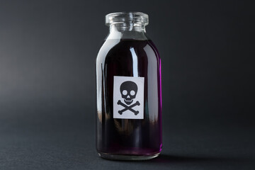 Bottle of poison with warning sign on grey background, closeup
