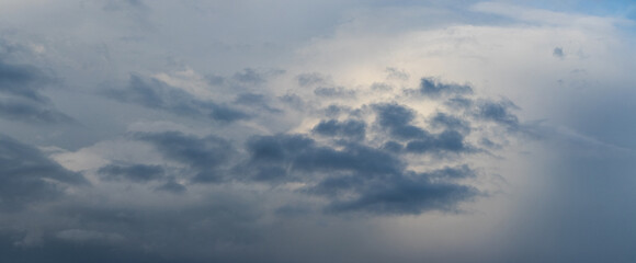 Obraz premium A gray stormy sky partially illuminated by sunlight, creating a dramatic effect of changing weather