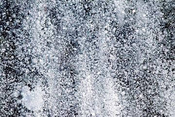 A general view of the surface of a frozen river, covered with air bubbles and ice crystals, forming...