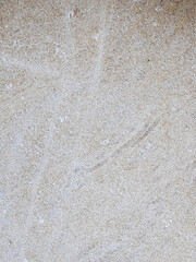 An abstract texture of a gray-beige stone or a sand-sprinkled surface, creating a uniform, detailed background
