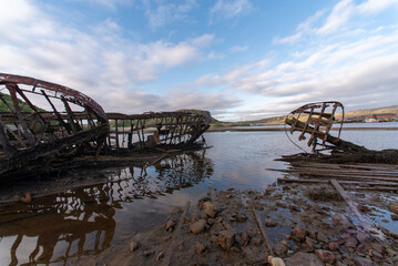 old abandoned sunken ship in the water at the ship cemetery