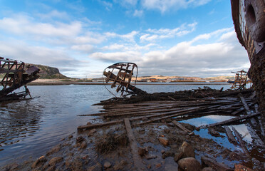 old abandoned sunken ship in the water at the ship cemetery