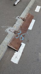 A Rusty Metal Plate Displaying Parking Number 36, An Urban Infrastructure Element