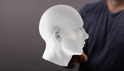 Stock photo of a 3D human head model in a person's hand.  Artificial intelligence, technology,...