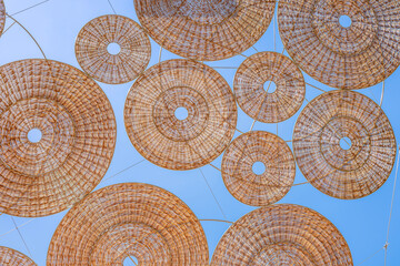 Abstract Background of Woven Wicker and Rattan Parasols Creating an Artistic Shade Canopy Over a Street. Interlocking Geometric Circles