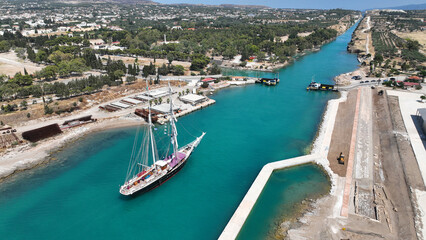 Fototapeta premium Aerial drone photo of classic sailing boat crossing narrow Corinth canal of Isthmus from West submersible bridge and narrow opening of Corinthian gulf to Saronic gulf, Loutraki, Greece