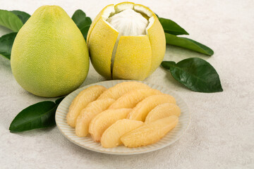 Fresh pomelo fruit with leaf on white table background.