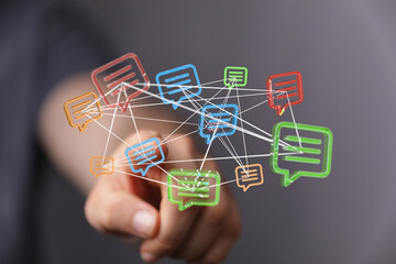 Digital communication concept. Hand touching network of colorful speech bubbles, conveying online connection and information sharing. Technology
