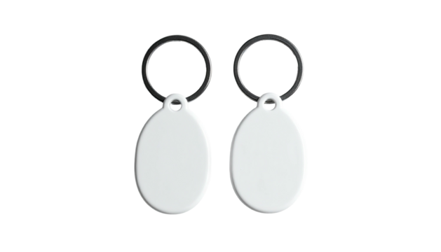 Two blank white oval keychains with metal rings, isolated on a stark black background